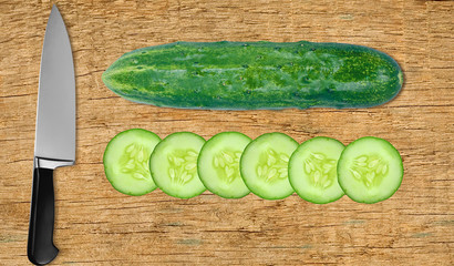 cucumber and knife on cutting board isolated on white