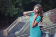 © oleg_p_100 - Outdoor lifestyle portrait of pretty young girl, wearing in blue dress on urban background. Creative color toned image.