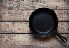 Traditional Cast Iron Skillet Pan On Vintage Wooden Table Background. Kitchen Equipment