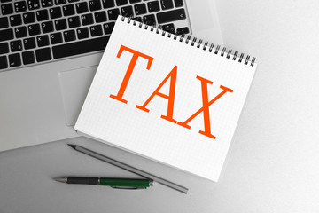 Poster - Tax Concept. Notebook on laptop keyboard, on light background