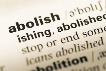 Close up of old English dictionary page with word abolish