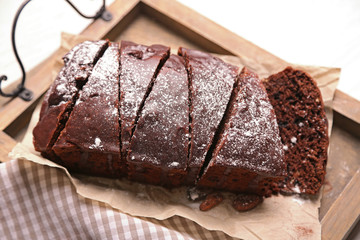 Poster - Chocolate sliced cake with icing and powdered sugar on a tray