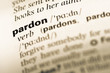 Close up of old English dictionary page with word pardon