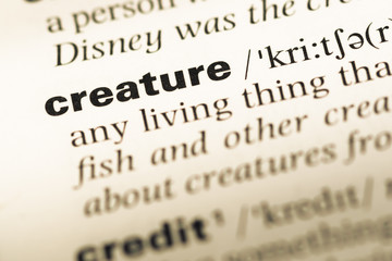 Close up of old English dictionary page with word creature