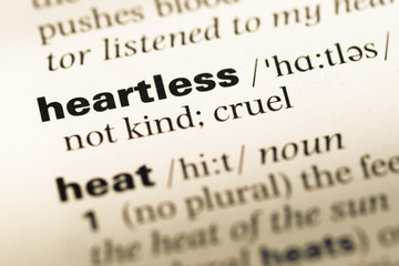 Wall Mural - Close up of old English dictionary page with word heartless
