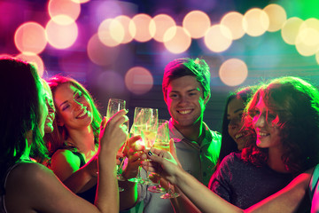 Poster - smiling friends with glasses of champagne in club