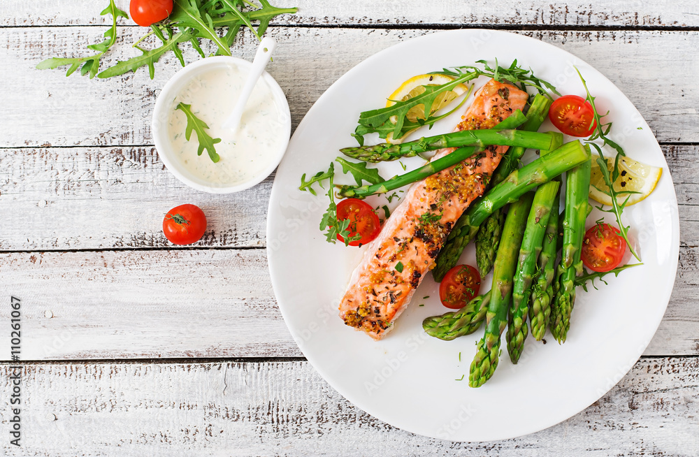 Baked salmon garnished with asparagus and tomatoes with herbs. Top view - obrazy, fototapety, plakaty 