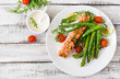 canvas print picture - Baked salmon garnished with asparagus and tomatoes with herbs. Top view