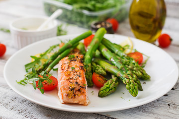 Wall Mural - Baked salmon garnished with asparagus and tomatoes with herbs