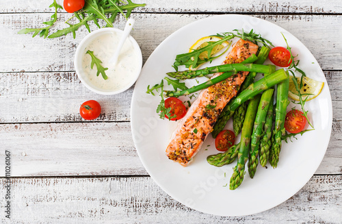 Fotografía Baked salmon garnished with asparagus and tomatoes with herbs
