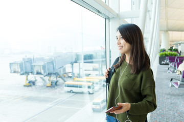 Poster - Woman listen to song with cellphone at airport