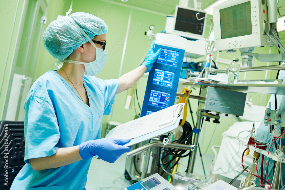 Surgery assistant perfusionist operating a modern heart lung machine - obrazy, fototapety, plakaty 