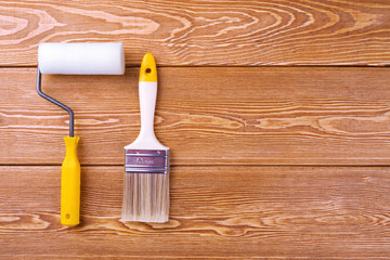 Paintbrush and roller on a wooden background 