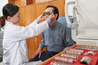 © DragonImages - Young ophthalmologist examining eyes of mature patient