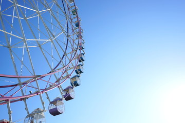 Colorful Ferris wheel in a sunny blue sky