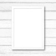 White blank picture frame on white wood wall.