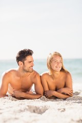 Poster - Young couple lying on sand