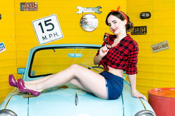  Young Woman With Pinup Hair Style And Makeup Posing on blue retro car