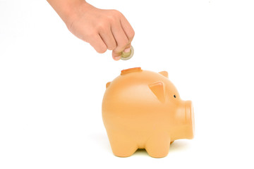 Money Saving Ideas.hand putting a coin into piggy bank.