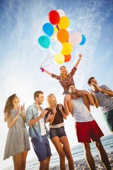 Wall Mural - Friends dancing on sand with balloon