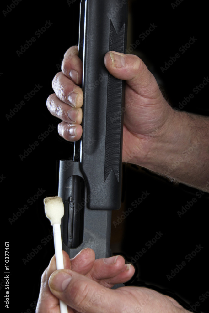 Gunsmith using swab to clean the inner rails of a pump action 20 guage ...