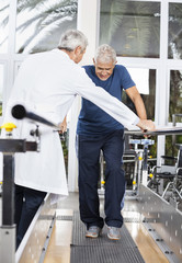 Wall Mural - Doctor Examining Senior Man Walking In Fitness Studio