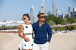 © abelena - Young dating couple in love walking on the Dubai beach.