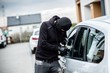 Car thief trying to break into a car with a screwdriver