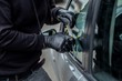 © Daniel Jędzura - Car thief trying to break into a car with a screwdriver.