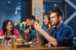 © Syda Productions - man with smartphone and friends at restaurant