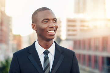 Young African businessman smiling while looking away optimistical