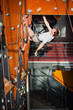© anatoliy_gleb - Athletic male climber with special equipment climbs on an indoor rock-climbing wall