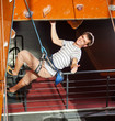 © anatoliy_gleb - Athletic guy with special equipment and rope climbs on indoor wall, shows sign of class