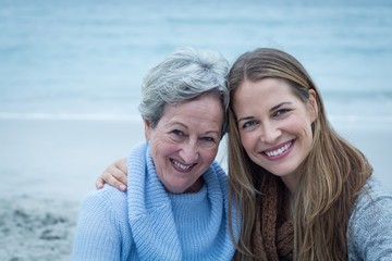 Wall Mural - Smiling mother with daughter at beach