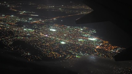 Wall Mural - Aerial view of illuminated city seen through aeroplane at night