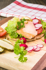 Wall Mural - Fresh homemade pita sandwich with hot smoked salmon, letuce and vegetables.