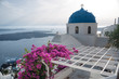 White church with blue dome on Santorini Island, Greece. The view toward Caldera sea with cruise ship arriving.