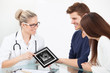 © Andrey Popov - Doctor Showing Ultrasound Scan Of Baby To Happy Couple