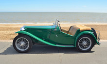  Classic Green Sports Car Parked On Seafront Promenade.