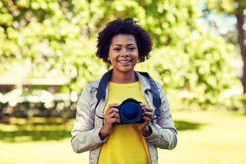 Wall Mural - happy african woman with digital camera in park