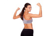 In love with sport. A young beautiful woman in gym clothes flexing her arms against white isolated background.