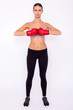 Ready to fight. Concentrated sporty woman in sportwear and boxing gloves looking at camera while standing isolated on white background.