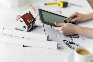 Wall Mural - close up of hand with blueprint and tablet pc