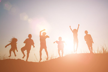 Wall Mural - Silhouette Children playing on summer sunset happy time