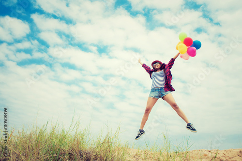 Beautiful Girl jumping with balloons on the beach Poster