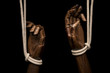 Black hands attached with white rope