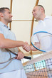 Two men shaking hands over the tennis court net
