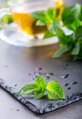 Wall Mural - Mint leaf. Mint leaves. Tea. Mint Tea. Herbal tea. Tea in a glass cup, mint leaves, dried tea, sliced lime. herbs tea and mint leaves on a slate plate in a restaurant or teahouse tea room.