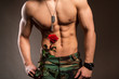 Muscular shirtless macho man with rose