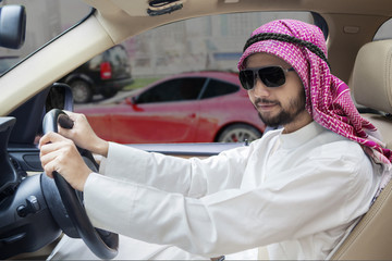 Male Arabic worker driving a car